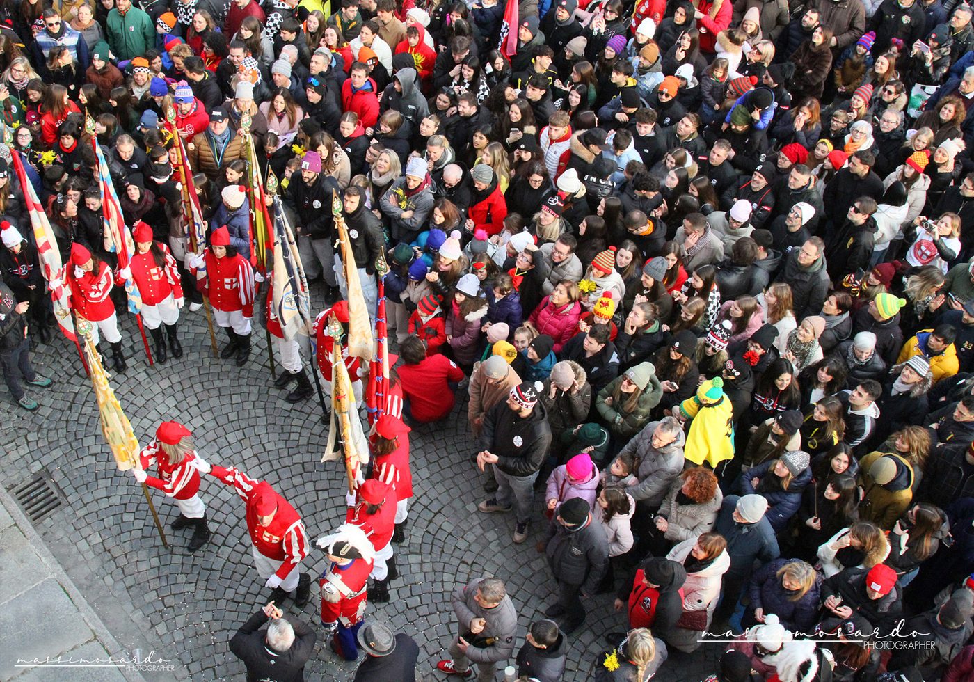 The Alzata degli Abba: the red and white flag holders in front of the crowd, in Ivrea