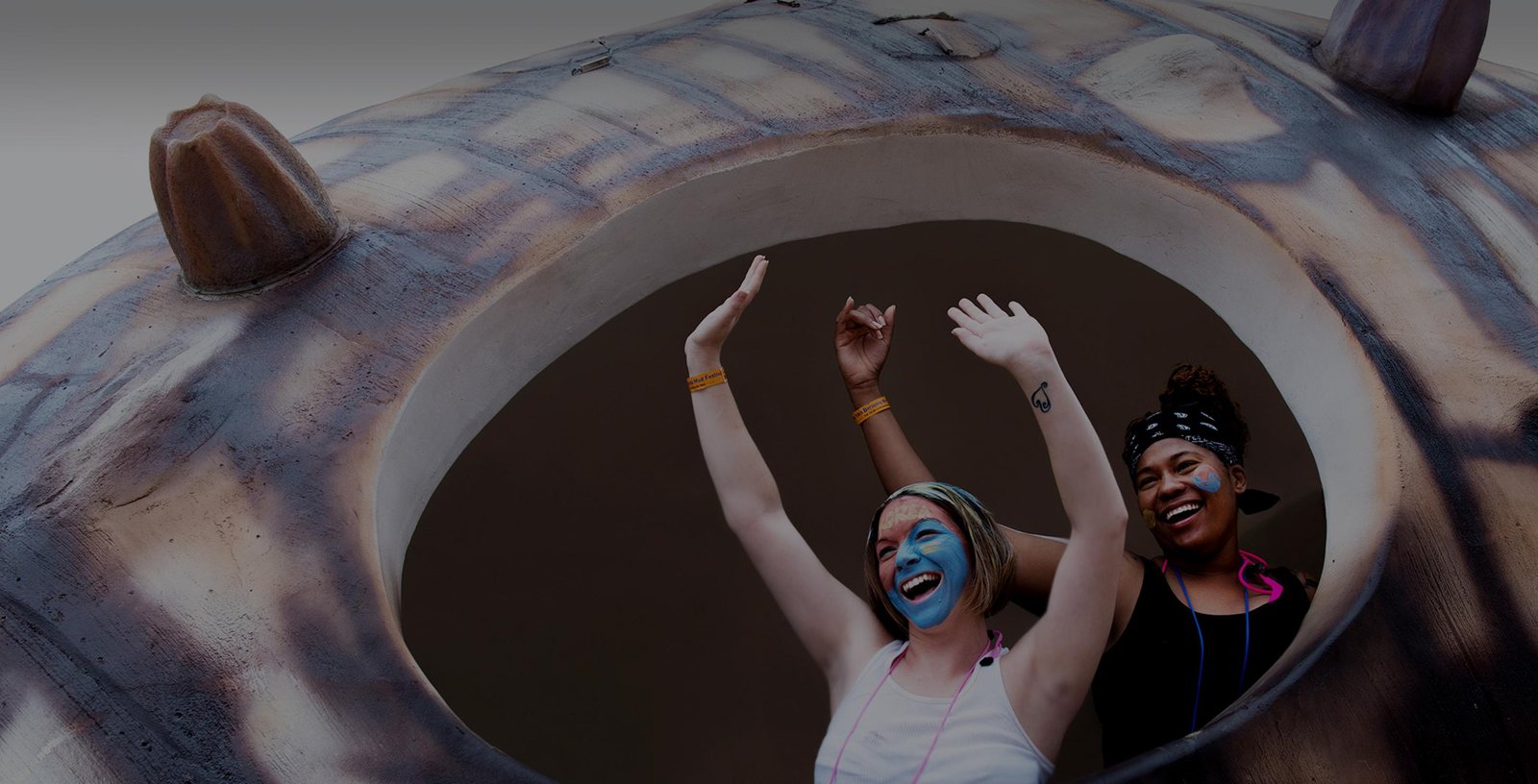 Two festivalgoers with a colorful mud-painted face at the Boryeong Mud Festival