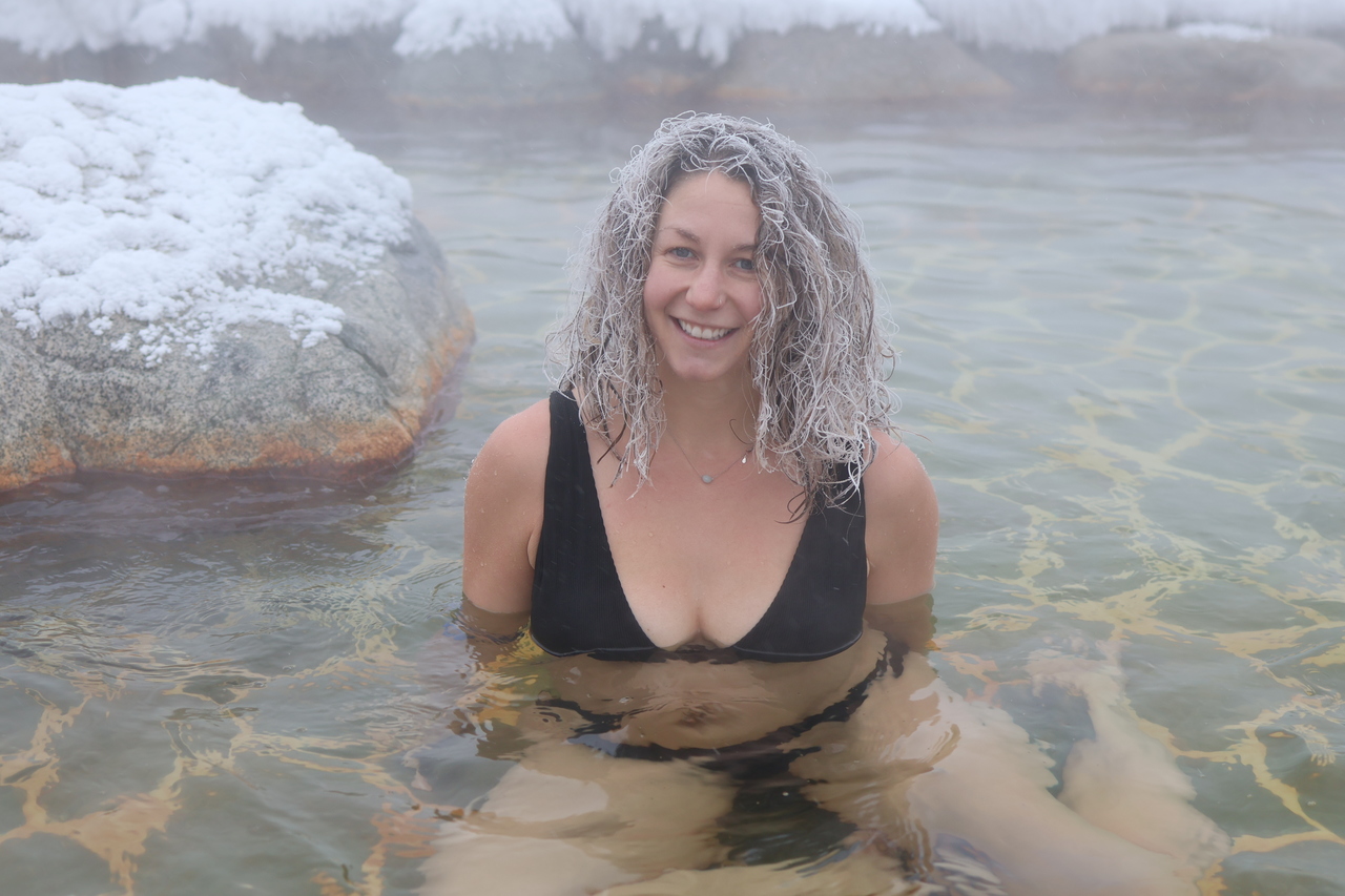 A participant in the drunken loops, smiling in a hot spring basin Eclipse