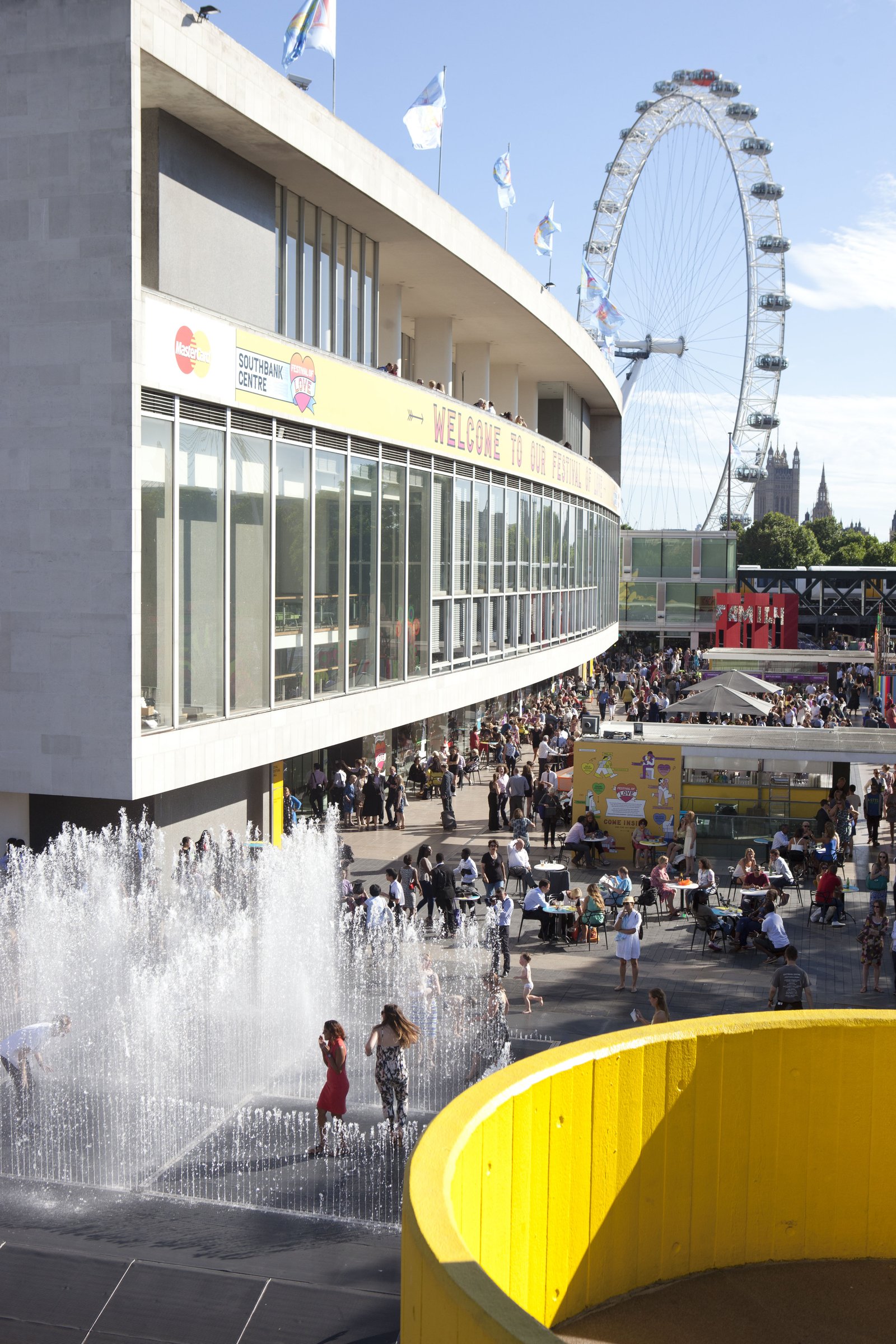 The curved façade of the Royal Festival Hall during the Festival of Love, fountains and crowds
