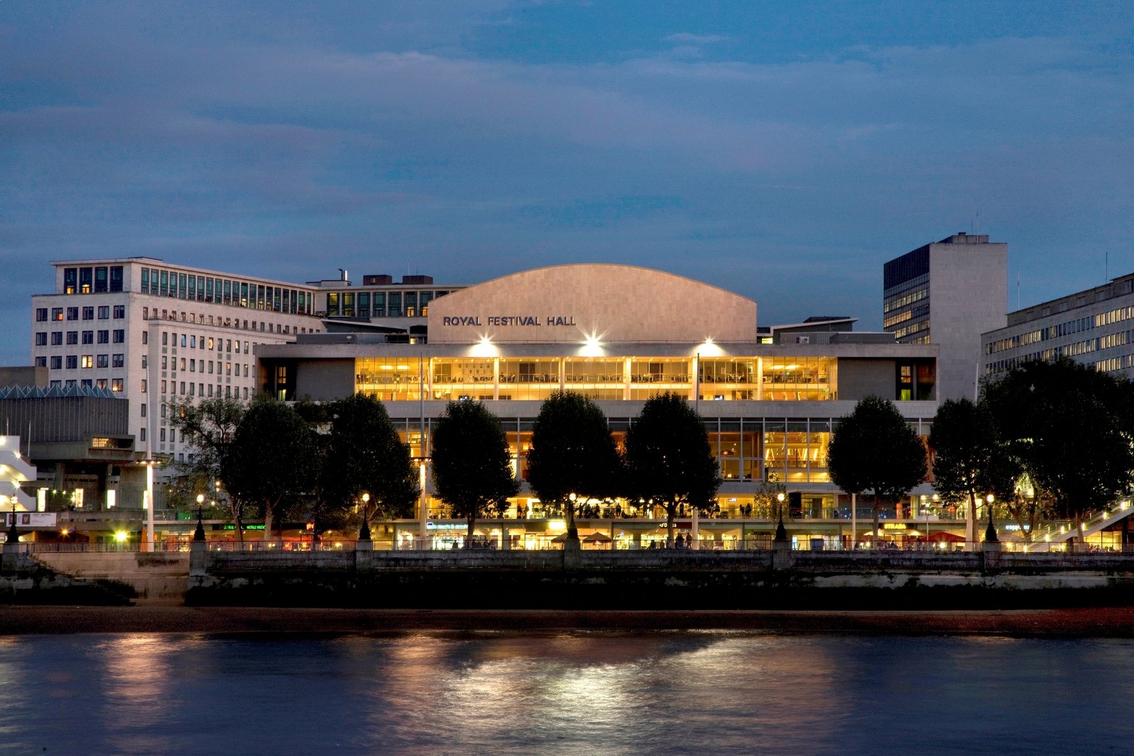 Royal Festival Hall illuminated at dusk, reflections on the Thames and London Eye