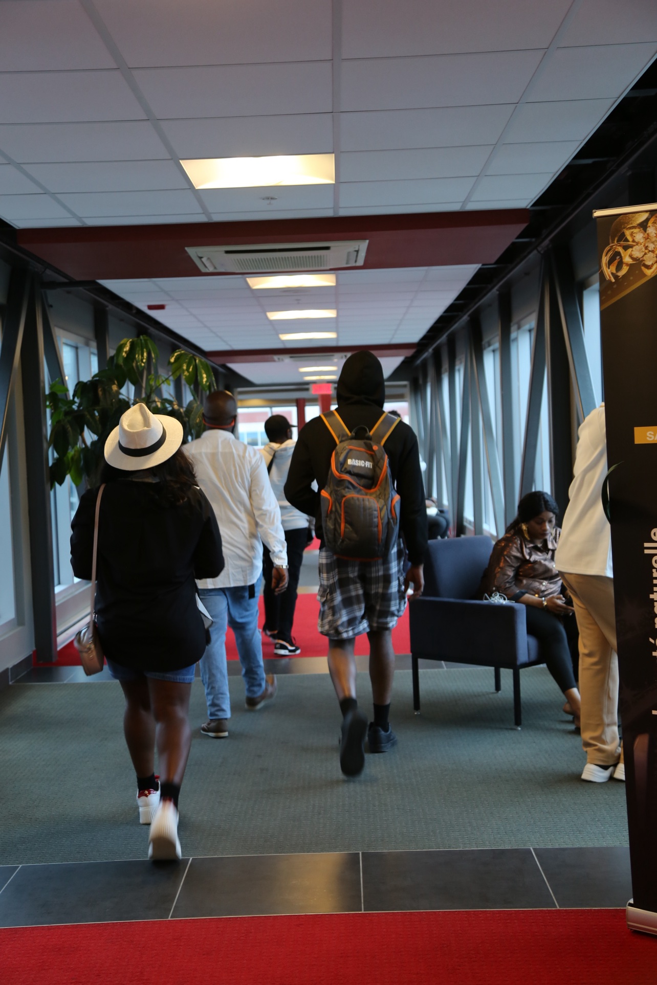 The glazed corridor and its red carpet, with guests