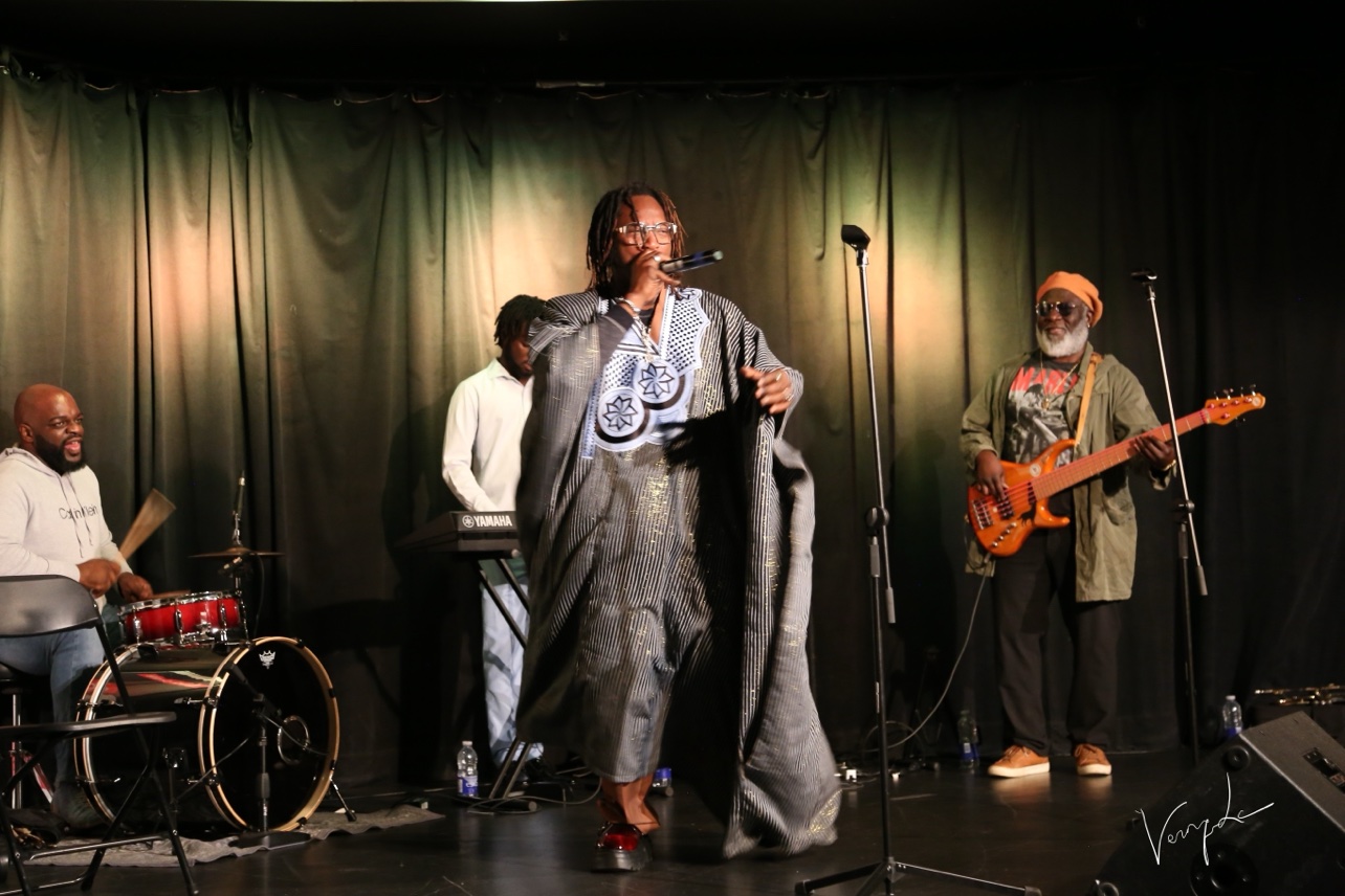 The singer in a boubou, the drums in the background