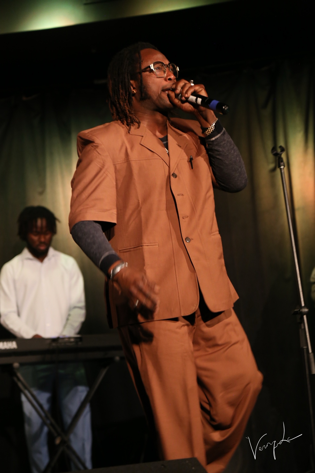 The singer in a beige ensemble on stage
